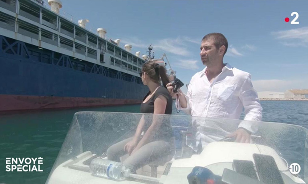 Gabi Paun on a speedboat with a journalist next to a live export ship